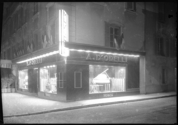 Au coin de la rue de l'As de carreau et de la place Corbis, les vitrines, l'entrée du magasin et une grande enseigne lumineuse.