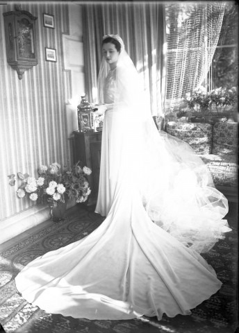 Dans un salon, la mariée debout prend la pose : plaque de verre 13x18 cm.