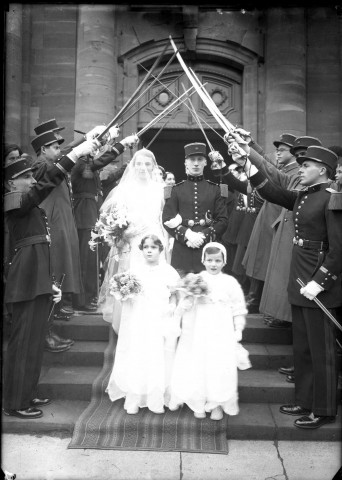 Couple de mariés sortant de l'église escorté par une haie d'honneur de militaires en uniforme sabre au clair, devant eux deux petites filles d'honneur : plaque de verre 13x18 cm.