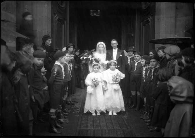 Couple de mariés sortant de l'église, escorté par une haie d'honneur formée de jeunes scouts (même cliché que 51 Fi 592) : négatif souple 12,6x17,6 cm.