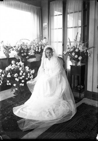 Mariée assise vêtue d'une longue robe nuptiale.