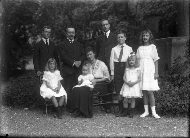 Sept frères et sœurs posent avec le petit dernier de la famille installé sur les genoux de la grande sœur : plaque de verre 13x18 cm.