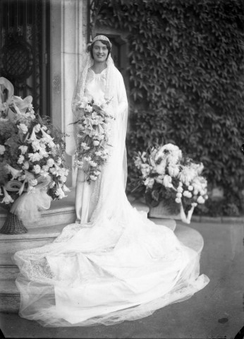 Devant un mur de vigne vierge, la mariée, son bouquet à la main : plaque de verre 13x18 cm.