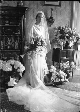 Une mariée debout prenant la pose une gerbe de lys dans ses bras : plaque de verre 13x18 cm.