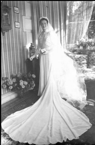Dans un salon, la mariée debout prend la pose (même cliché que 51 Fi 526) : tirage papier en noir et blanc 11,3x17,5 cm.