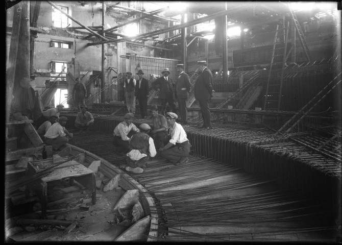 Ouvriers travaillant sur des coffrages en ferraillage pour couler le béton. Echafaudages en bois.