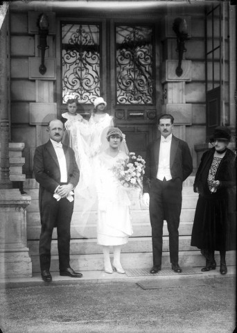 Sur les marches du château, deux enfants d'honneur tiennent le voile de la mariée.