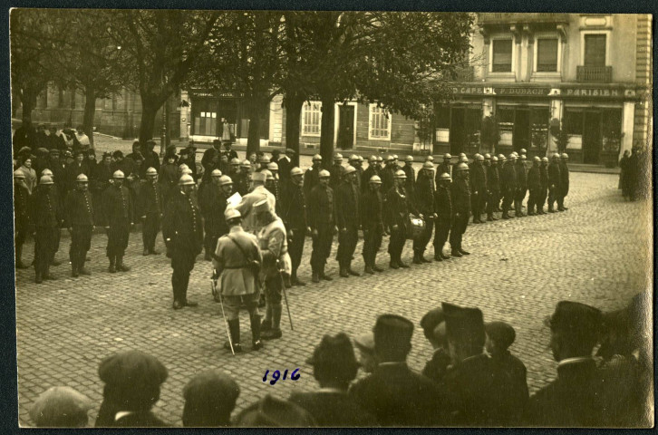 Belfort, place d'Armes, remise de la Croix de Guerre, par le général Hanoteau, aux sous-officiers et sapeurs du corps des pompiers de Belfort cités à l'Ordre des Troupes d'Etapes pour leur intervention suite aux bombardements allemands.