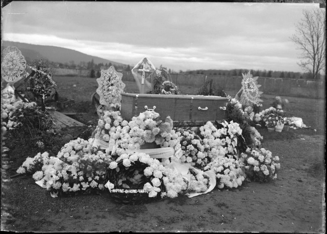 Dans un cimetière, un cercueil recouvert de gerbes de fleurs et de couronnes mortuaires : plaque de verre 13x18 cm, [s.l.].