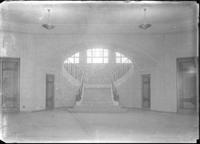 Vue intérieure, hall d'entrée avec son grand escalier réservé à l'administration, lumière différente.
