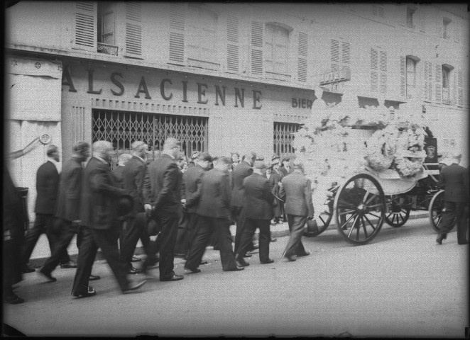 Le cortège funèbre passe devant la brasserie Alsacienne, 32 rue Stractman.