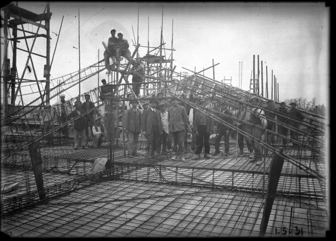Préparation de coffrage sur le toit, les ouvriers regardent le photographe.