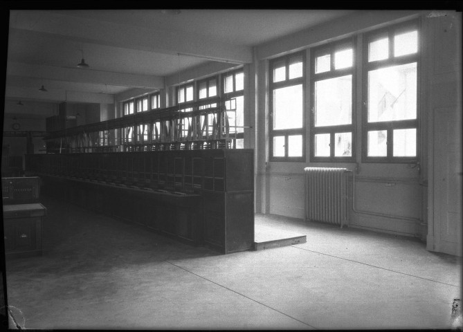 Salle des téléphones et des télégraphes avec fenêtres, meubles en bois.