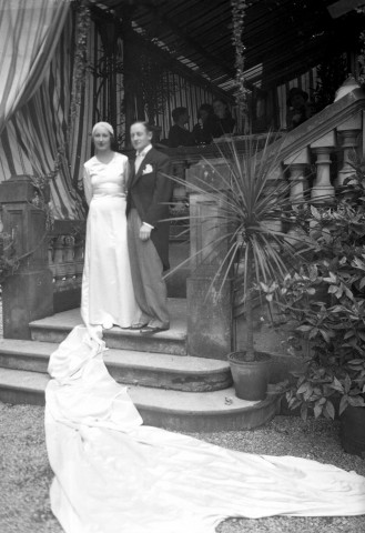 Sur les marches menant à une terrasse ombragée, un couple de mariés : négatif souple 12,6x17,6 cm.