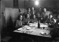 Dans une cuisine un groupe d'hommes attablés, sans doute des militaires : plaque de verre 13x18 cm, [s.l.]. 