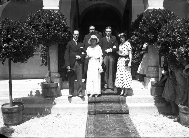 A la suite des mariés, deux couples sur le perron, l'une des femmes porte une jolie robe à pois : plaque de verre 13x18 cm.